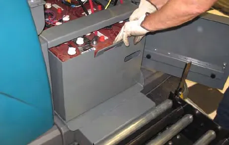 Battery case being pulled from the machine onto the battery cart