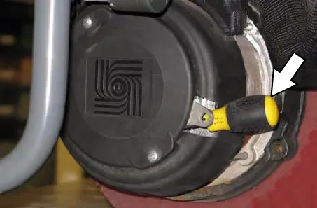 Drive wheel hub with a screwdriver inserted between the electronic brake lever and the hub, and an arrow pointing to it
