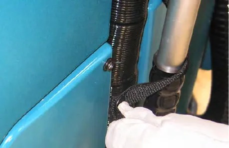 Hand unsnapping the vacuum wand lanyard from the solution tank