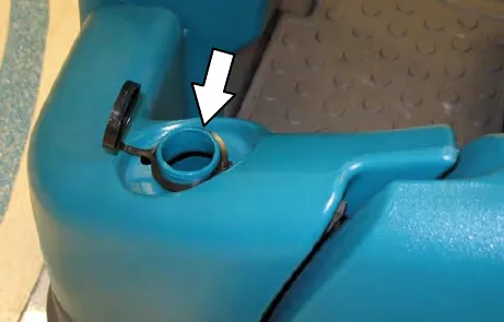 Detergent tank filler opening with an arrow to the opening