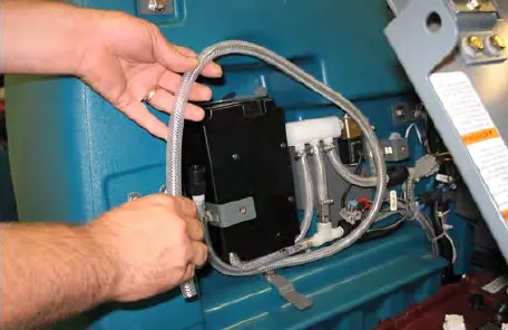 Hands pulling the drain hose out of the ec-H2O compartment