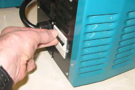 A hand turning on the charger's power switch on the side of the charger