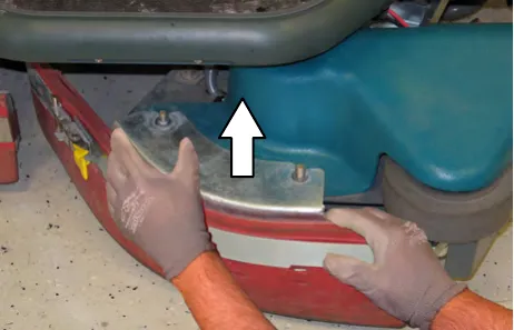 Hands lifting the side brush squeegee assembly off, with an arrow pointing up