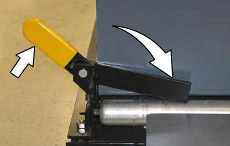 Yellow handle on the battery cart being pulled up to lower the stop bar