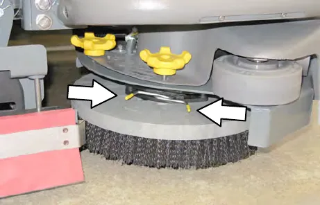 Side brush assembly with arrows pointing to the two spring handles