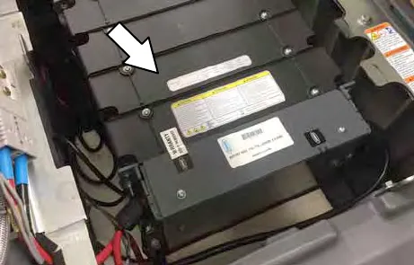 Lithium-ion case battery in the battery compartment, with an arrow to its top label