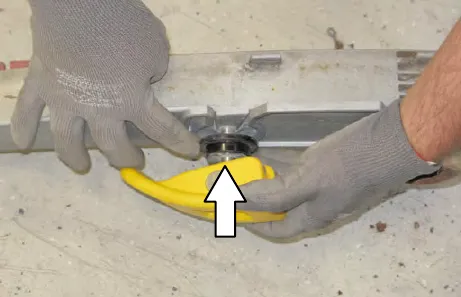 Gloved hands sliding a yellow retainer into the squeegee assembly, with an arrow pointing up