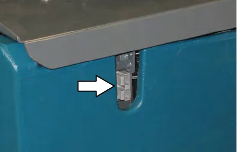 Remote battery charge connector below the seat edge, with an arrow pointing to it
