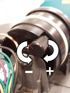 Backup alarm volume knob with arrows: minus is counter-clockwise, plus is clockwise