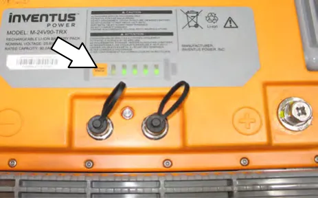 Top of a lithium-ion battery pack with an arrow pointing to the power button and the row of discharge indicator lights