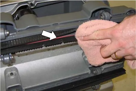Wiping the squeegee blades with a cloth, with an arrow pointing to the blade