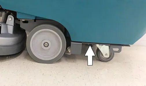 Designated jacking location under the machine frame, marked by an arrow