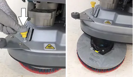 Pressing down on the yellow pad release plunger so the pad drops to the floor