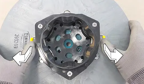 Pressing the yellow spring clips down and outward to the open position