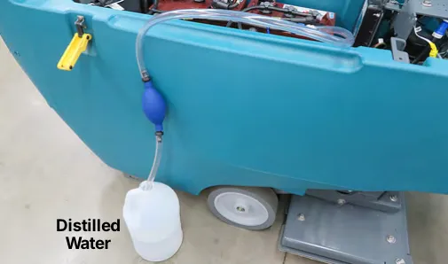 Hand pump hose submerged in a bottle of distilled water