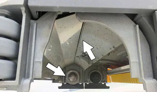 Debris buildup on the underside of the cylindrical scrub head, idler plates and drive hubs